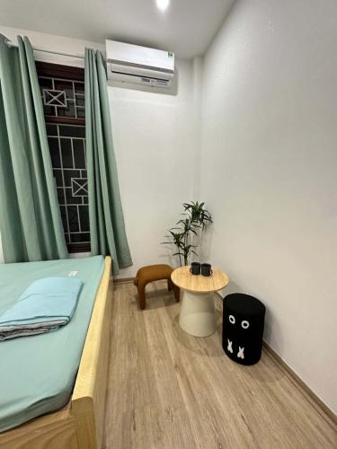 a small room with a bed and a table at Nhà Happy in Hanoi
