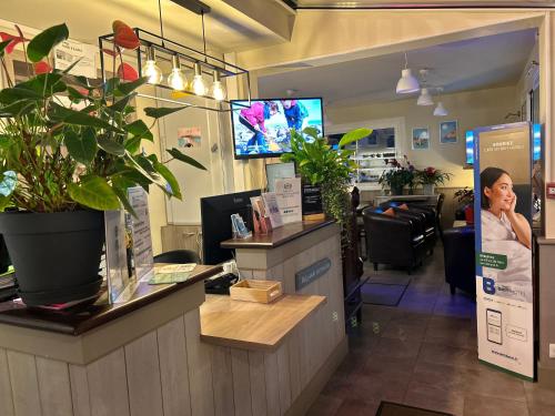 a woman standing at the counter of a salon at BRIT HOTEL Lannion-Perros Guirec in Lannion