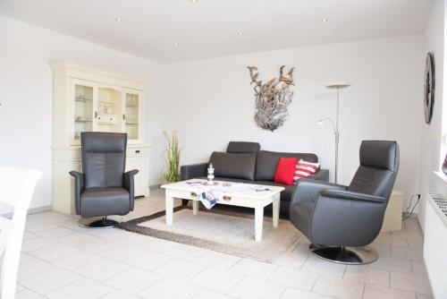 a living room with a couch and two chairs and a table at Passat in Norddeich