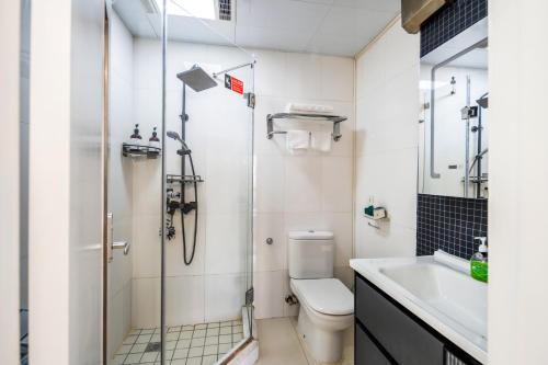a bathroom with a shower and a toilet and a sink at Tech-X Jing'an Hotel in Shanghai