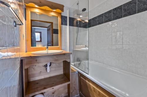 une salle de bain avec un lavabo, une baignoire et un miroir dans l'établissement Résidence Les Hauts De Preclaux - Appartement avec balcon et vue sur les pistes MAE-4461, aux Orres