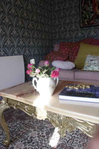 a living room with a coffee table with flowers on it at Les Chanterelles La souris des champs in Étival-Clairefontaine