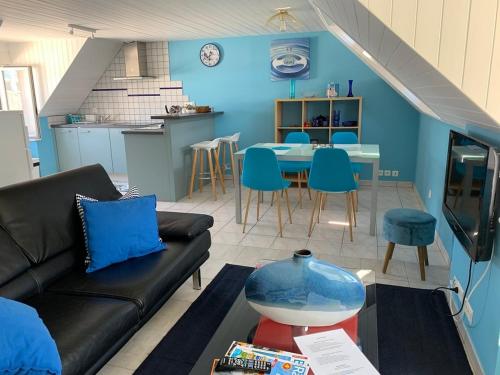 a living room with a couch and a table at Le Bleu, T2 proche plage de Morgat in Crozon