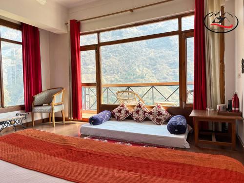 a bedroom with a bed with a large window at Himalayan Abode Joshimath in Joshīmath