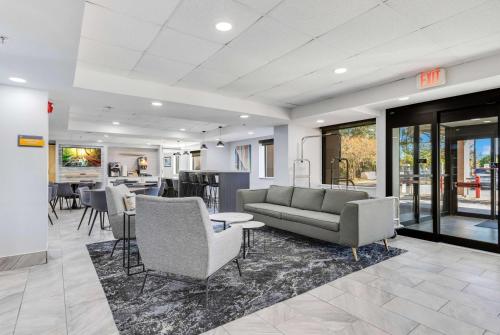 a living room with a couch and a table at La Quinta Inn & Suites by Wyndham Jacksonville Mandarin in Jacksonville