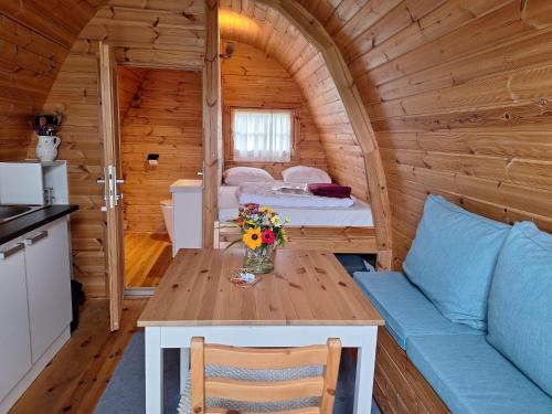 a room with a table and a bed in a cabin at Luxe Houten Pod 3 Aagtekerke Dichtbij Zee en Natuur in Aagtekerke