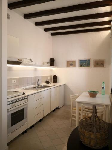 a kitchen with white cabinets and a table and a sink at Un'oasi tra i limoni in Naso