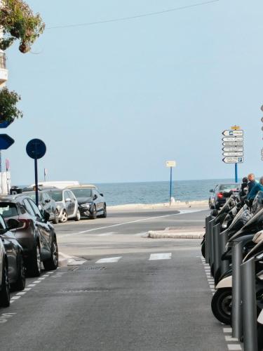 - un parking avec des voitures garées à côté de l'océan dans l'établissement La Residence du Casino, à Menton