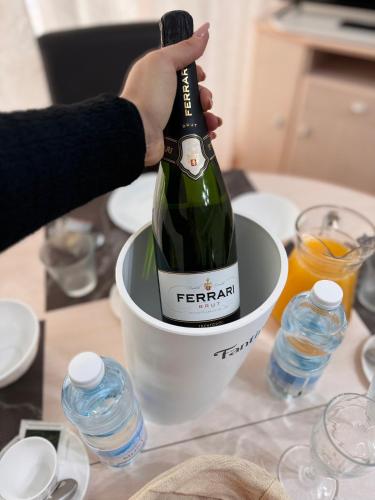 une personne tenant une bouteille de champagne dans un seau dans l'établissement La Residence du Casino, à Menton