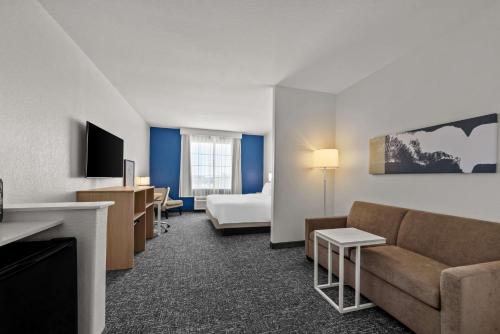 a hotel room with a couch and a bed at Spark by Hilton Selma in Selma