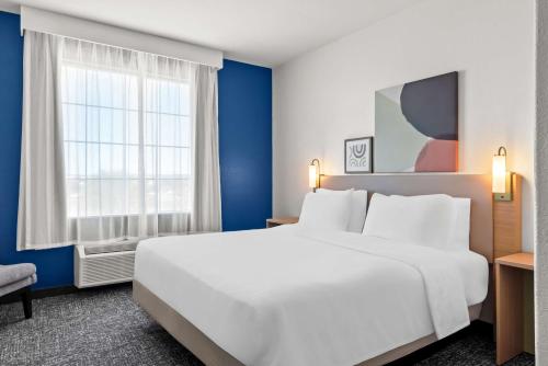 a hotel room with a large white bed and a window at Spark by Hilton Selma in Selma