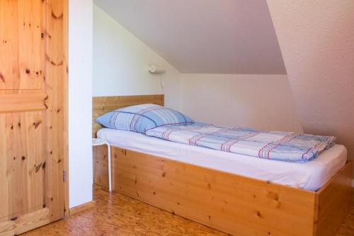 a bed with a wooden frame in a room at Ferienwohnung Ferienhäuser am Brocken, 80 qm 3 Schlafzimmer in Ilsenburg