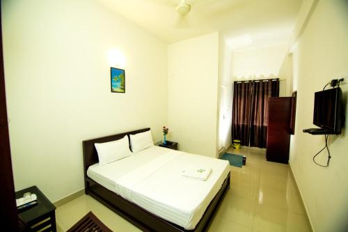 a bedroom with a white bed in a room at Regal residency in Perintalmanna