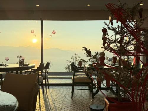 a room with a christmas tree and a large window at Fuxian Lake Three Thousand French Manor Hotel in Xujiadu
