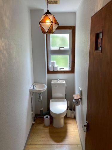 a small bathroom with a toilet and a window at Painagama House in Miyako-jima