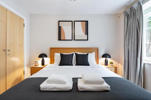 a bedroom with a large bed with two pillows at Bridgeview Retreat, 2Bed 2Bridge in London