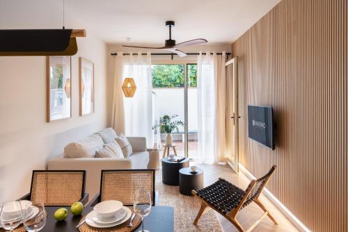 セビリアにあるMagno Apartments Roblesのソファとテーブルと椅子のあるリビングルーム