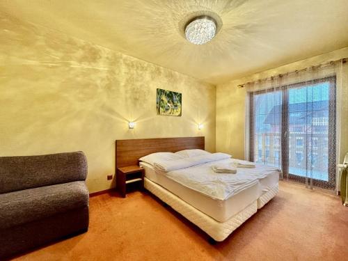 a bedroom with a bed and a couch at Apartmán D308 Tatragolf in Veľká Lomnica