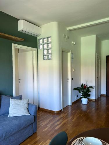 Una sala de estar con un sofá azul y una planta. en scirocco 25, en Piombino