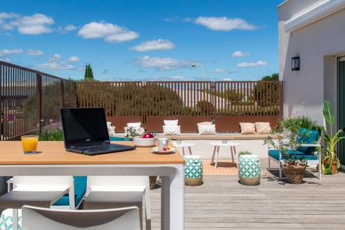 a laptop computer sitting on a table on a patio at Kyriad Montpellier Est - Lunel in Lunel