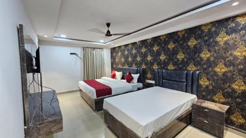 a hotel room with two beds and a television at Hotel Park View Pithampur in Akolia