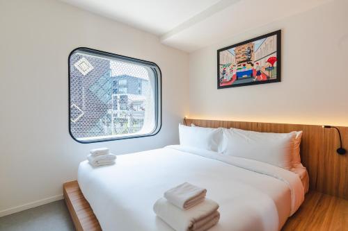 a bedroom with a white bed and a window at VELA be Bangkok Siam in Bangkok
