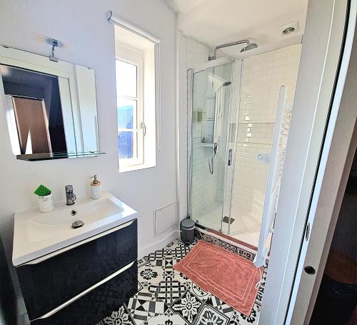 une salle de bain blanche avec une douche et un lavabo dans l'établissement Les Bons Enfants 4, à Rouen