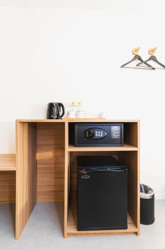 a wooden desk with a microwave and a refrigerator at VELA be Bangkok Siam in Bangkok