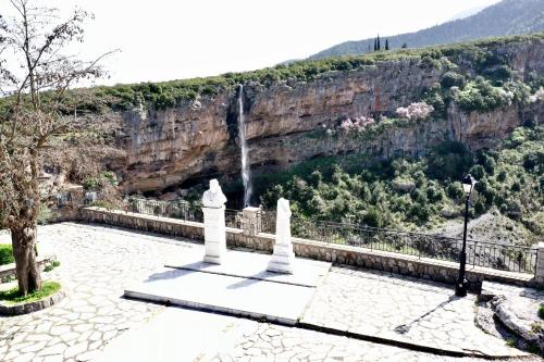 a monument with a waterfall in the background at Το ΦΑΡΑΓΓΙ ΤΟΥ ΠΑΡΝΑΣΣΟΥ 4 in Velítsa