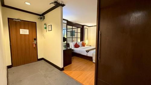 a room with a bed and a door leading to a bedroom at Grand Business Inn in Bangkok