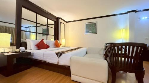a bedroom with a bed and a desk and a chair at Grand Business Inn in Bangkok