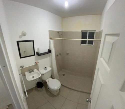 a white bathroom with a toilet and a sink at Casa Curicó Viñedos in Las Adjuntas