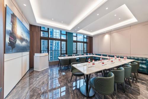 a conference room with tables and chairs and large windows at Merrihod Hotel - Guangzhou South Station Jinlong Subway Station Branch in Shunde
