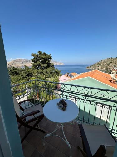 a balcony with a table and chairs and the ocean at Niriides Hotel Apartments in Symi