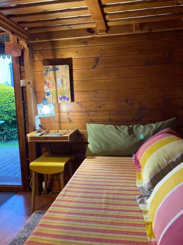 a bedroom with a bed and a desk with a lamp at La Cabane du Raideur in Cilaos