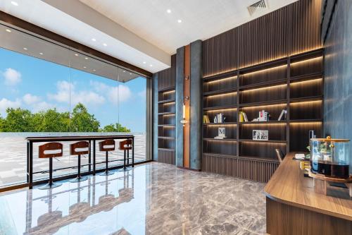 a room with a table and chairs and a large window at Merrihod Hotel - Guangzhou South Station Jinlong Subway Station Branch in Shunde