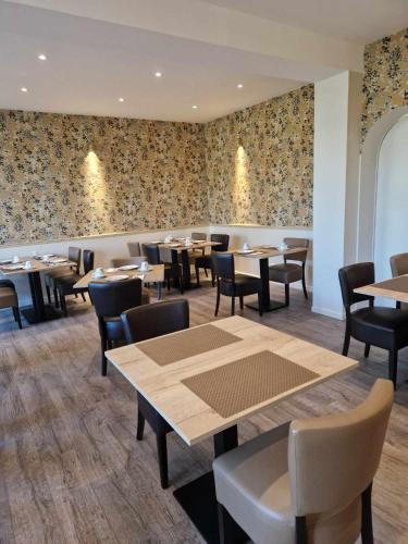 een eetkamer met tafels en stoelen en behang bij Sure Hotel by Best Western Saint-Quentin Ouest Le pot d étain in Holnon