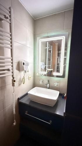 a bathroom with a sink and a mirror at Adlia Flight Spot in Batumi