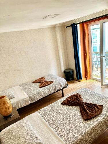 two beds sitting in a room with a window at 7Lisbon Downtown Private Bedroom With Balcony in Lisbon