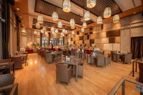 um restaurante vazio com mesas, cadeiras e luzes em Prana Resort Nandana em Bangrak Beach