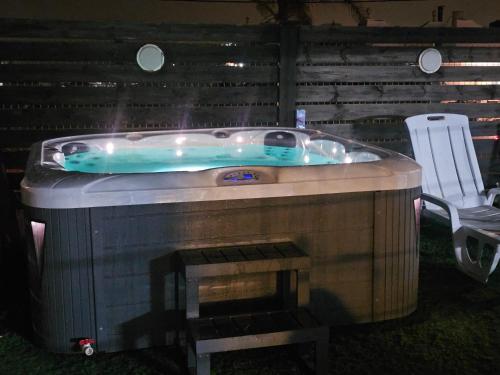 a jacuzzi tub with a chair next to it at עדי הכרמל in Dāliyat el Karmil