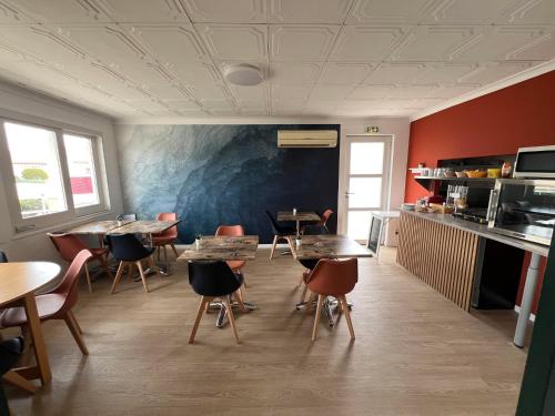 un restaurant avec des tables et des chaises dans une salle dans l'établissement Hôtel le Canetois, à Canet