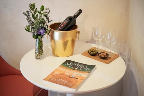 a table with a bottle of wine and a book and glasses at Agriturismo Montecolombo by Il Ritorno in Sirolo