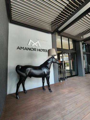 a black horse statue in front of a building at AMANOR Hotel Chiang Mai in Chiang Mai