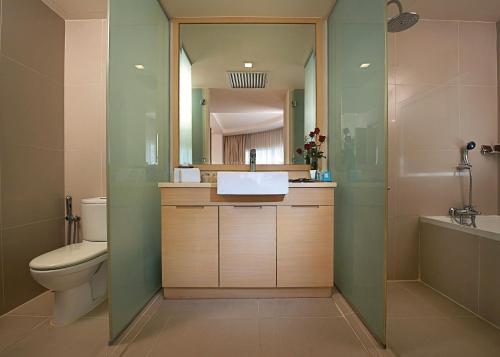 a bathroom with a sink and a toilet and a mirror at ANSA Hotel Kuala Lumpur in Kuala Lumpur