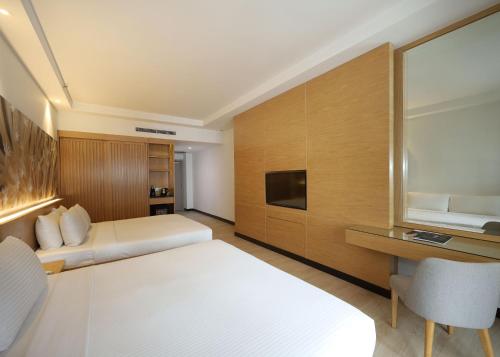 a hotel room with two beds and a television at ANSA Hotel Kuala Lumpur in Kuala Lumpur