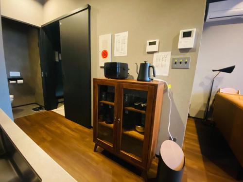 ein Zimmer mit einem Holzschrank mit zwei Töpfen darauf in der Unterkunft Js STAY OTARU II in Otaru