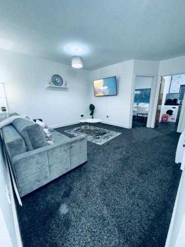 a living room with a couch and a tv at SwankyApartmentDudleyNearM6 in Coseley