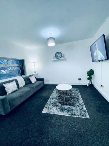 a living room with a couch and a table at SwankyApartmentDudleyNearM6 in Coseley
