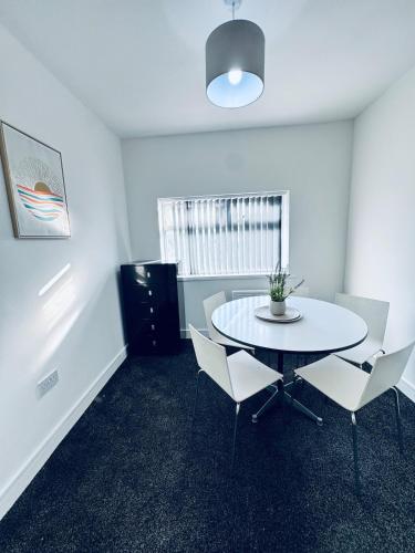 a room with a table and chairs and a window at SwankyApartmentDudleyNearM6 in Coseley